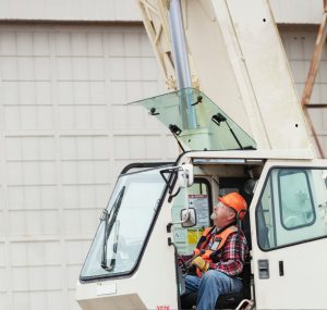 A crane operator focused on safety, preventing distractions on the job site.
