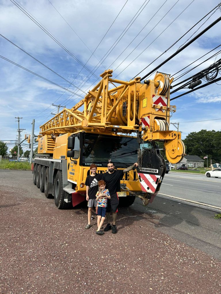 Vincente, standing with his two younger children, in front of a crane years ago.