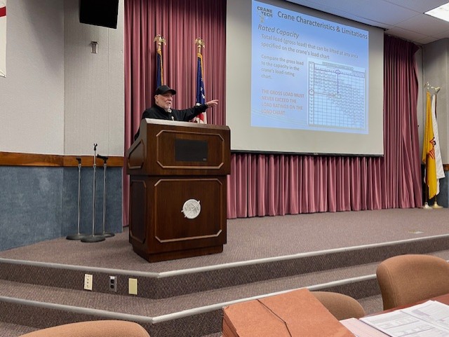 Bruce Johnson at a podium presenting to crane and rigging students